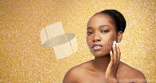 Image of portrait of african woman touching her face