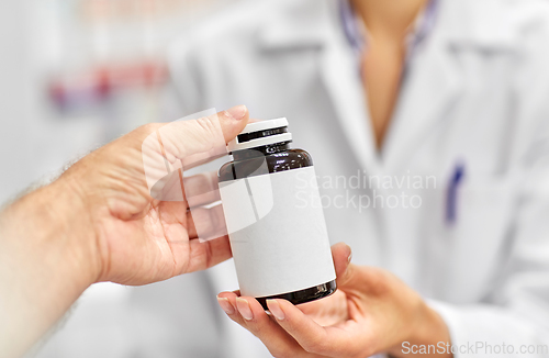 Image of pharmacist and customer with medicine at pharmacy