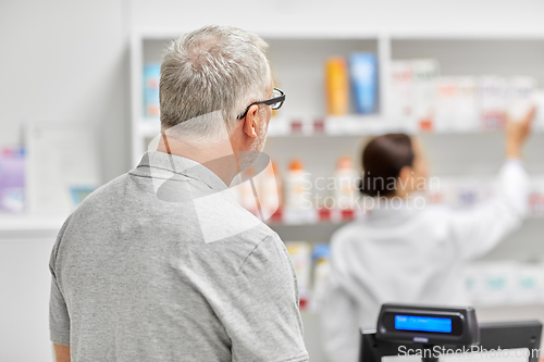 Image of senior man buying medicine at pharmacy