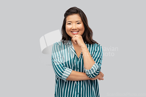 Image of happy asian woman over grey background