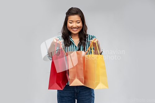 Image of happy asian woman with shopping bags