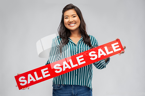 Image of happy smiling young asian woman with sale banner