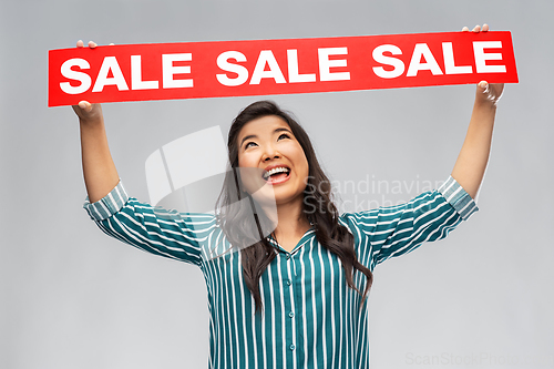 Image of happy smiling young asian woman with sale banner