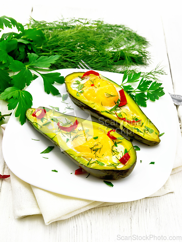 Image of Scrambled eggs with peppers in avocado on board