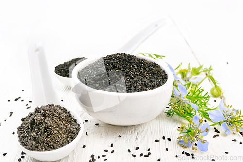 Image of Seeds of black cumin in bowl on wooden board