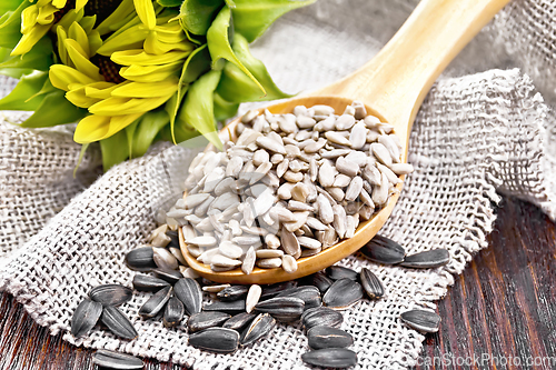 Image of Seeds sunflower in spoon with flower on board