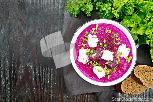 Image of Soup puree of beetroot with salted cheese in bowl on black board