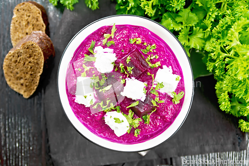 Image of Soup puree of beetroot with salted cheese in bowl on board top