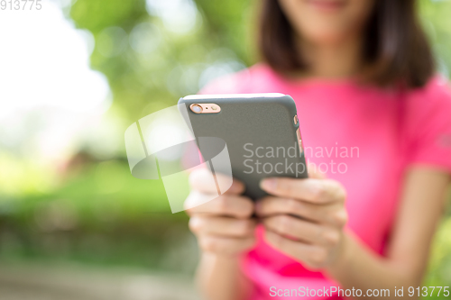 Image of Woman use of cellphone at outdoor park