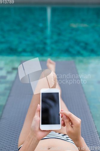 Image of Woman with bikini using mobile phone in swimming pool