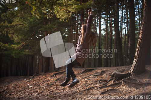 Image of Woman at bungee in autumn forest
