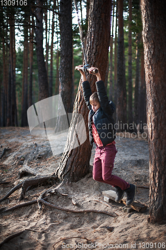 Image of Teen boy at bungee in autumn forest