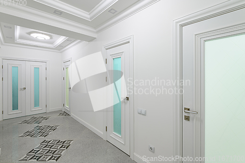 Image of interior of white hallway with doors