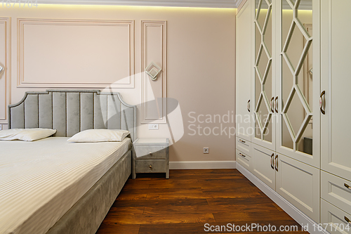 Image of Beige and brown modern bedroom interior with double bed