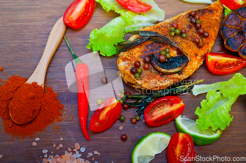 Image of wood fired hoven cooked chicken breast on wood board