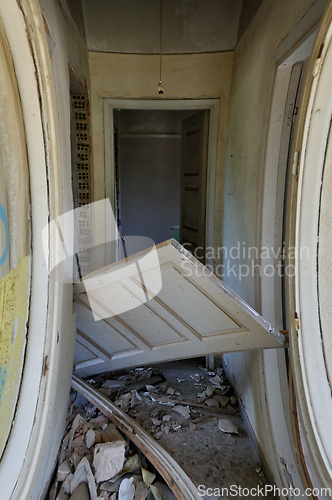 Image of unhinged door abandoned house corridor