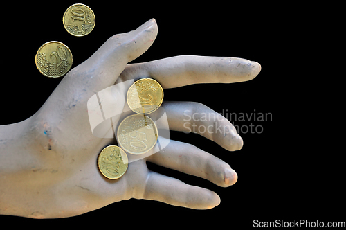Image of worn doll hand holding euro coins