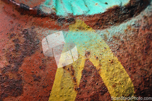 Image of yellow arrow on rusty metal surface