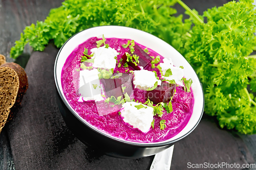 Image of Soup puree of beetroot with salted cheese in bowl on board