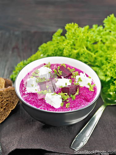 Image of Soup puree of beetroot with salted cheese in bowl on napkin