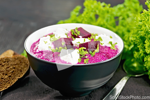 Image of Soup puree of beetroot with salted cheese in bowl on wooden boar