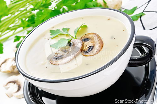 Image of Soup puree of champignon in bowl on wooden board