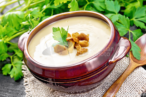 Image of Soup puree of chanterelle in bowl on wooden board