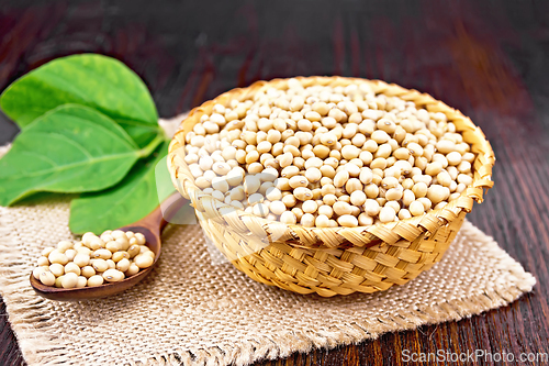 Image of Soybeans in wicker bowl with leaf on wooden board