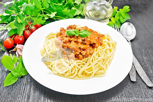 Image of Spaghetti with bolognese on dark wooden board