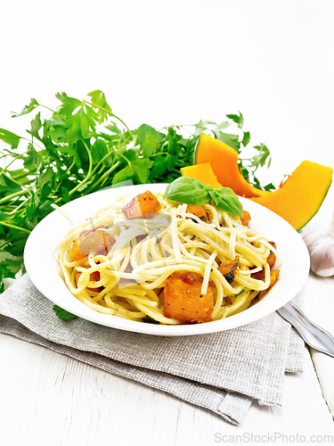 Image of Spaghetti with pumpkin in plate on wooden board