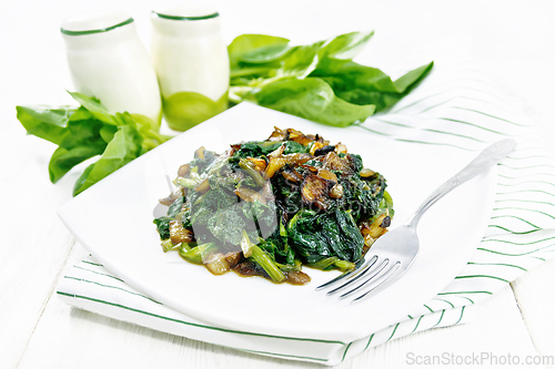 Image of Spinach fried with onions in plate on light board