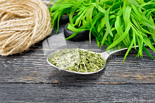 Image of Tarragon dried in spoon on dark board