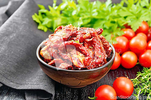 Image of Tomatoes sun-dried in bowl with napkin on board