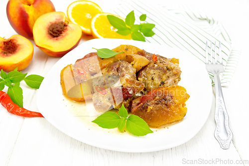 Image of Turkey with peaches in plate on light wooden board