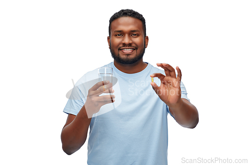 Image of african american man with pill and glass of water