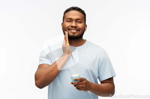 Image of happy african man applying wax to his beard
