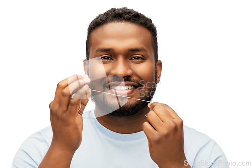 Image of happy african man with dental floss cleaning teeth