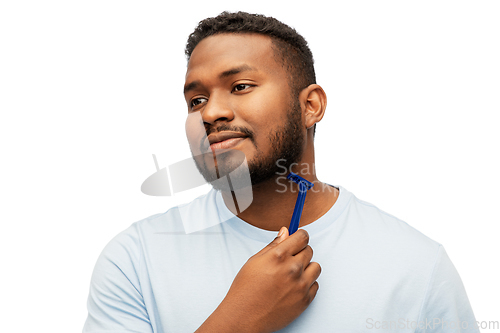 Image of african man shaving beard with razor blade