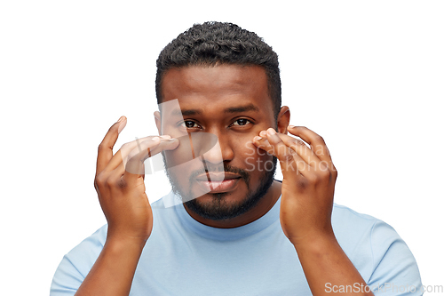 Image of african american man touching his face