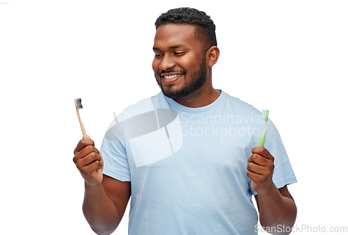 Image of african man with wooden and plastic toothbrushes
