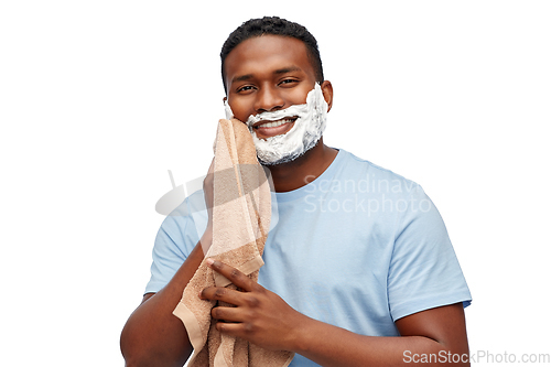 Image of smiling african man with shaving cream and towel