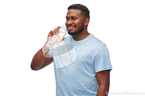Image of happy african man drinking water from glass bottle