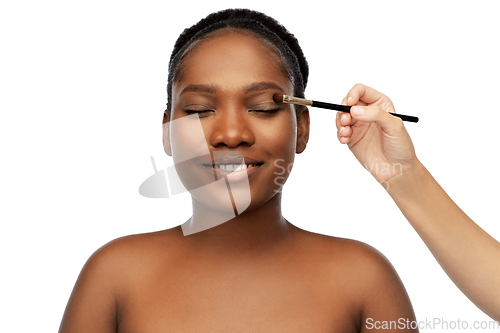 Image of face of african woman and hand with make up brush