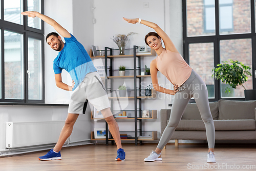 Image of happy couple exercising at home