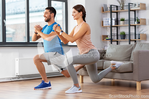 Image of couple exercising and doing lunge at home