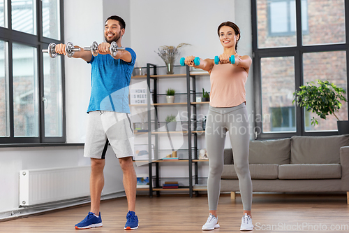 Image of happy couple exercising at home