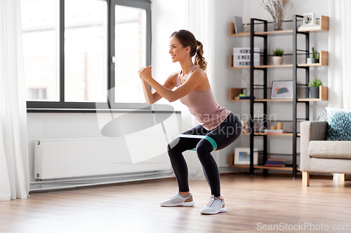 Image of woman exercising with resistance band at home