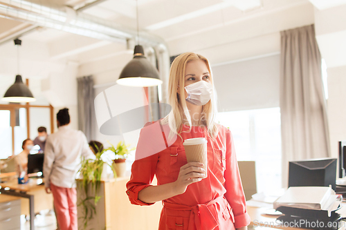 Image of female office worker in mask with coffee cup