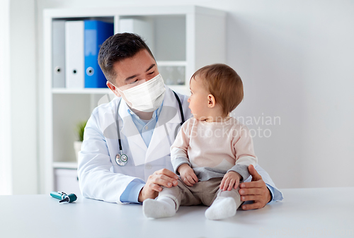 Image of doctor or pediatrician in mask with baby at clinic