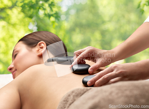 Image of close up of woman having hot stone massage at spa